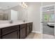 Ensuite bathroom features double vanity with dark cabinets and doorway to the main bedroom at 9535 Beautiful Way, Winter Garden, FL 34787