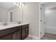 A sleek bathroom showcases double sinks and a door to the shower with tiled walls at 9535 Beautiful Way, Winter Garden, FL 34787