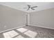 A sun-filled carpeted bedroom is well lit and spacious with a ceiling fan at 9535 Beautiful Way, Winter Garden, FL 34787