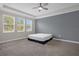 This spacious bedroom features a tray ceiling, neutral paint, carpet and three windows at 9535 Beautiful Way, Winter Garden, FL 34787