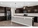 Modern kitchen featuring dark cabinets, stainless steel appliances, and a large island at 9535 Beautiful Way, Winter Garden, FL 34787