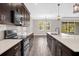 Modern kitchen with stainless steel appliances, white quartz countertops, dark cabinets, and tile backsplash at 9535 Beautiful Way, Winter Garden, FL 34787