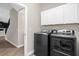 A functional laundry room features front load washer/dryer, tile floor, and built-in cabinets at 9535 Beautiful Way, Winter Garden, FL 34787