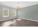 Bright living room with wood-look tile flooring, crown molding, and a decorative chandelier at 9535 Beautiful Way, Winter Garden, FL 34787