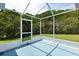 A screened patio featuring a blue floor and green bushes surrounding the screen at 956 Chula Ct, Lady Lake, FL 32159