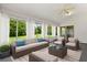 Bright sunroom with neutral furnishings, ceiling fan, and large windows offering views of the green backyard at 956 Chula Ct, Lady Lake, FL 32159