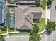 An aerial view showcases the home's lush landscaping, screen-enclosed pool, and tile roof at 10319 Lavande Dr, Orlando, FL 32836