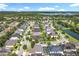 An aerial view featuring a neighborhood with mature trees, sparkling lakes, and community pools at 10319 Lavande Dr, Orlando, FL 32836