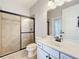 Well-lit bathroom with granite countertop, tiled shower and glass doors, complete with modern fixtures at 10319 Lavande Dr, Orlando, FL 32836