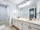 Bright bathroom with double vanities, neutral tile, and large mirror at 10319 Lavande Dr, Orlando, FL 32836