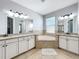 Inviting bathroom with dual vanities, granite countertops, and a large soaking tub for ultimate relaxation at 10319 Lavande Dr, Orlando, FL 32836