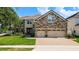 Stunning stone-accented home with three-car garage and meticulously landscaped front yard at 10319 Lavande Dr, Orlando, FL 32836