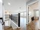 Hallway with wooden floors and an ornate railing leading to a bright living area at 10319 Lavande Dr, Orlando, FL 32836