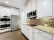 Modern kitchen featuring white cabinets, granite countertops, and stainless steel appliances at 10319 Lavande Dr, Orlando, FL 32836