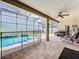 A screened-in pool with an outdoor seating area and ceiling fan at 10319 Lavande Dr, Orlando, FL 32836