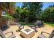Open backyard patio area with fire pit and chairs with view of fenced yard and trees at 105 John Anderson Dr, Ormond Beach, FL 32176