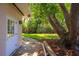 Backyard featuring green grass, brick paver path, lush trees and the home's back door at 105 John Anderson Dr, Ormond Beach, FL 32176