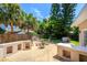 Wide open backyard patio area with fire pit, built-in features, fenced yard, and tropical trees at 105 John Anderson Dr, Ormond Beach, FL 32176