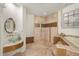 Elegant bathroom featuring a tiled walk-in shower, soaking tub, and sink with decorative mirror at 105 John Anderson Dr, Ormond Beach, FL 32176