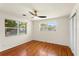 Well-lit bedroom features hardwood floors, a ceiling fan, and windows with treed views at 105 John Anderson Dr, Ormond Beach, FL 32176