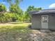 A quaint backyard features well-kept lawn with an access door on the home's exterior at 117 Burns Ave, Longwood, FL 32750