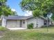 A view of the backyard showcasing well-kept lawn, landscaping, and access door at 117 Burns Ave, Longwood, FL 32750