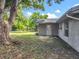 View of the backyard showcasing lush greenery, an access door, and well-maintained lawn at 117 Burns Ave, Longwood, FL 32750