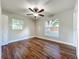 This bedroom features hardwood floors, a ceiling fan, and two windows for natural light at 117 Burns Ave, Longwood, FL 32750