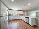 Bright kitchen features white cabinets, stainless appliances, and tile backsplash over wood floors at 117 Burns Ave, Longwood, FL 32750