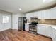 Modern kitchen with stainless steel appliances and tiled backsplash over wood floors at 117 Burns Ave, Longwood, FL 32750