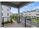 Balcony with wrought iron railings overlooking a tree-lined street with modern townhomes at 12468 Koshiba Aly, Orlando, FL 32827