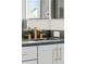 Bathroom with black marble countertop, gold faucet and hardware, and stylish white cabinets at 12468 Koshiba Aly, Orlando, FL 32827