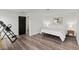Bedroom with wood floors, a bed, a black door, and minimal decor at 12468 Koshiba Aly, Orlando, FL 32827