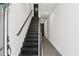 Modern hallway features sleek tile flooring and a stylish wooden staircase at 12468 Koshiba Aly, Orlando, FL 32827