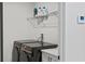 Modern laundry room featuring black front load washer and dryer with white cabinets at 12468 Koshiba Aly, Orlando, FL 32827