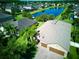 Aerial view of a house with a brick driveway and a beautiful pond nearby, surrounded by lush greenery at 12832 Sawgrass Pine Cir, Orlando, FL 32824