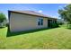 Grassy backyard with a view of the home's exterior and a partial fence at 12832 Sawgrass Pine Cir, Orlando, FL 32824