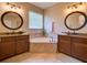 This bathroom features double sinks, granite counters, tile floors, and a corner soaking tub at 12832 Sawgrass Pine Cir, Orlando, FL 32824