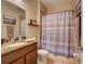 Bathroom with granite countertop, vanity, and a shower with blue and white striped curtain at 12832 Sawgrass Pine Cir, Orlando, FL 32824