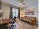 Cozy bedroom with large window, futon sofa, wood-look floors, and a ceiling fan with light at 12832 Sawgrass Pine Cir, Orlando, FL 32824
