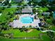 Aerial view of a community pool with lush landscaping and lounge areas around at 12832 Sawgrass Pine Cir, Orlando, FL 32824
