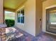 Inviting covered porch with brick flooring and stone pillar accents leading to an elegant front door at 12832 Sawgrass Pine Cir, Orlando, FL 32824