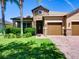 Covered front entrance featuring stone accents and a brick walkway leading to a charming glass-paneled door at 12832 Sawgrass Pine Cir, Orlando, FL 32824