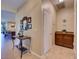 Bright hallway features tile flooring, with a table under a mirror, and a beverage station near a closed door at 12832 Sawgrass Pine Cir, Orlando, FL 32824