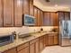 Modern kitchen with granite countertops, tiled backsplash, stainless appliances and dark wood cabinets at 12832 Sawgrass Pine Cir, Orlando, FL 32824