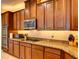 Kitchen featuring granite countertops, stainless steel appliances, dark wood cabinetry, and modern fixtures at 12832 Sawgrass Pine Cir, Orlando, FL 32824