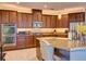 Gourmet kitchen showcasing stainless steel appliances, granite counters, dark wood cabinetry, and breakfast bar at 12832 Sawgrass Pine Cir, Orlando, FL 32824