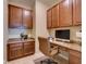 Well-lit home office with built-in cabinets, granite countertops, desk, and a comfortable leather chair at 12832 Sawgrass Pine Cir, Orlando, FL 32824