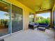 Covered patio with comfortable seating, ceiling fan, and sliding glass doors to inside at 12832 Sawgrass Pine Cir, Orlando, FL 32824