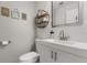 Bathroom featuring a modern sink, toilet, and decorative shelving, complemented by charming beach-themed wall art at 14524 Huntingfield Dr, Orlando, FL 32824